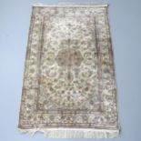 A cream-ground Persian silk rug. 150x94cm Good overall condition. Discoloured in places. Areas of