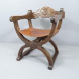 A modern carved oak Savonarola chair, with leather seat.