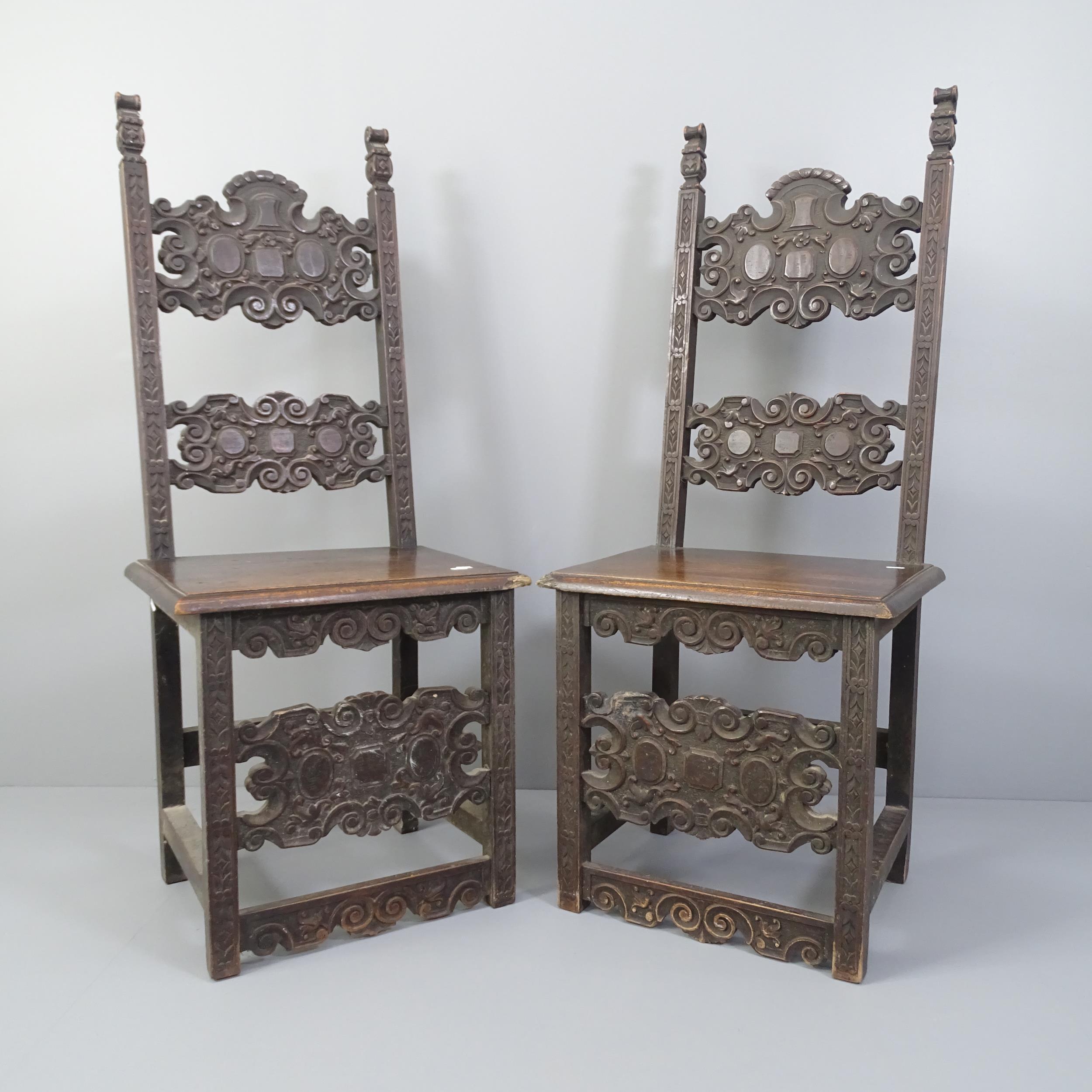 A pair of carved oak renaissance style hall chairs.