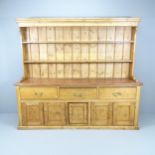 A 19th century Pine two section dresser, with open plate rack, three frieze drawers and cupboards