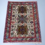 A red and cream-ground Caucasian rug. 175x130cm Good used condition. Some areas of staining.