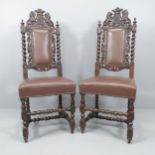 A pair of oak and faux-leather upholstered Carolean style hall chairs, with carved decoration,