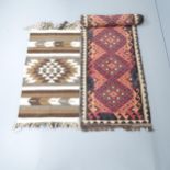 A red-ground Kilim runner, 357x73cm, and a woollen mat, 112x62cm. Rug has several holes to it mainly