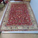 A red and cream-ground Tabriz carpet, with floral design. 338x298cm
