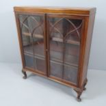 A antique mahogany bookcase, with two glazed doors, two adjustable shelves and raised on cabriole