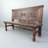 An antique carved and panelled oak hall seat. 145x91x50cm