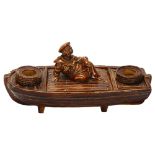 A 19th century novelty majolica inkwell in the form of a sailor and boat, marked R.H. 18 to base,