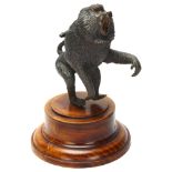 A cast bronze sculpture of a baboon on turned wooden plinth, height 17cm Good condition