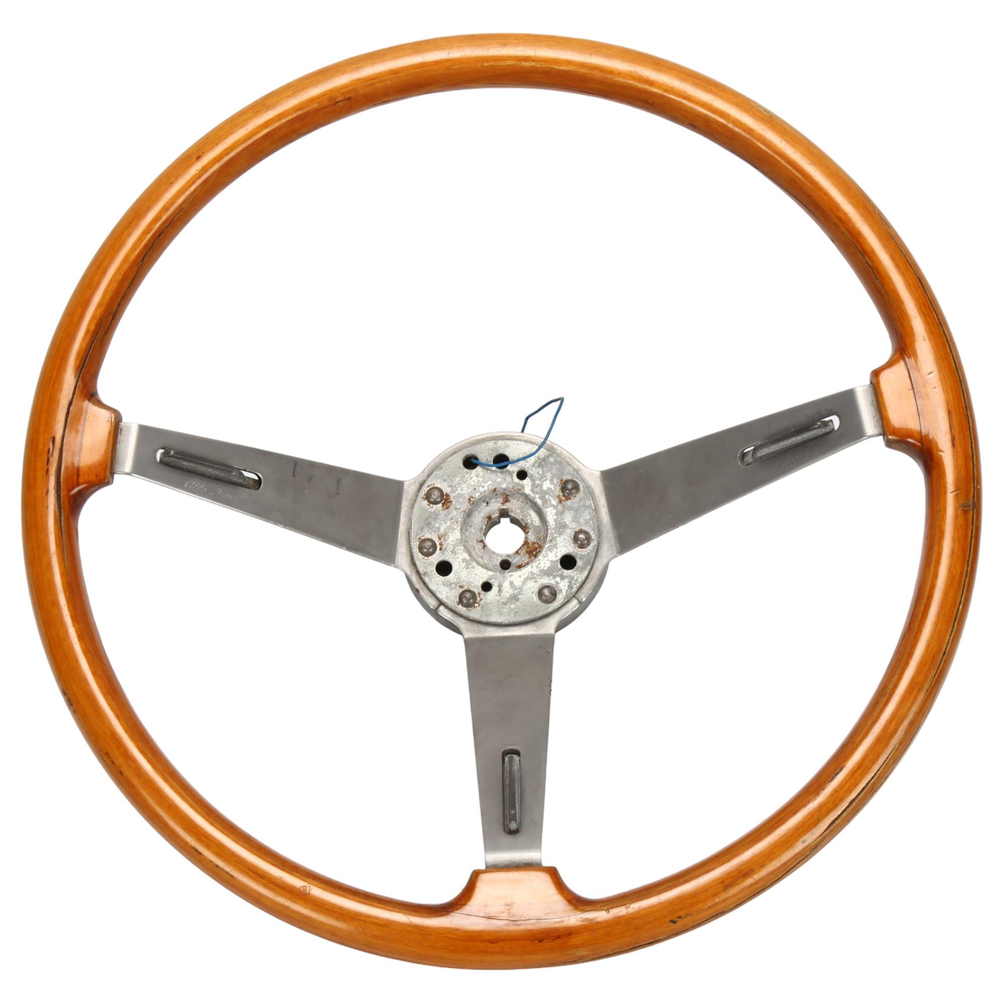 An Alfa Romeo steering wheel and user manual for GT Junior, engraved on metal "Alfa Romeo,