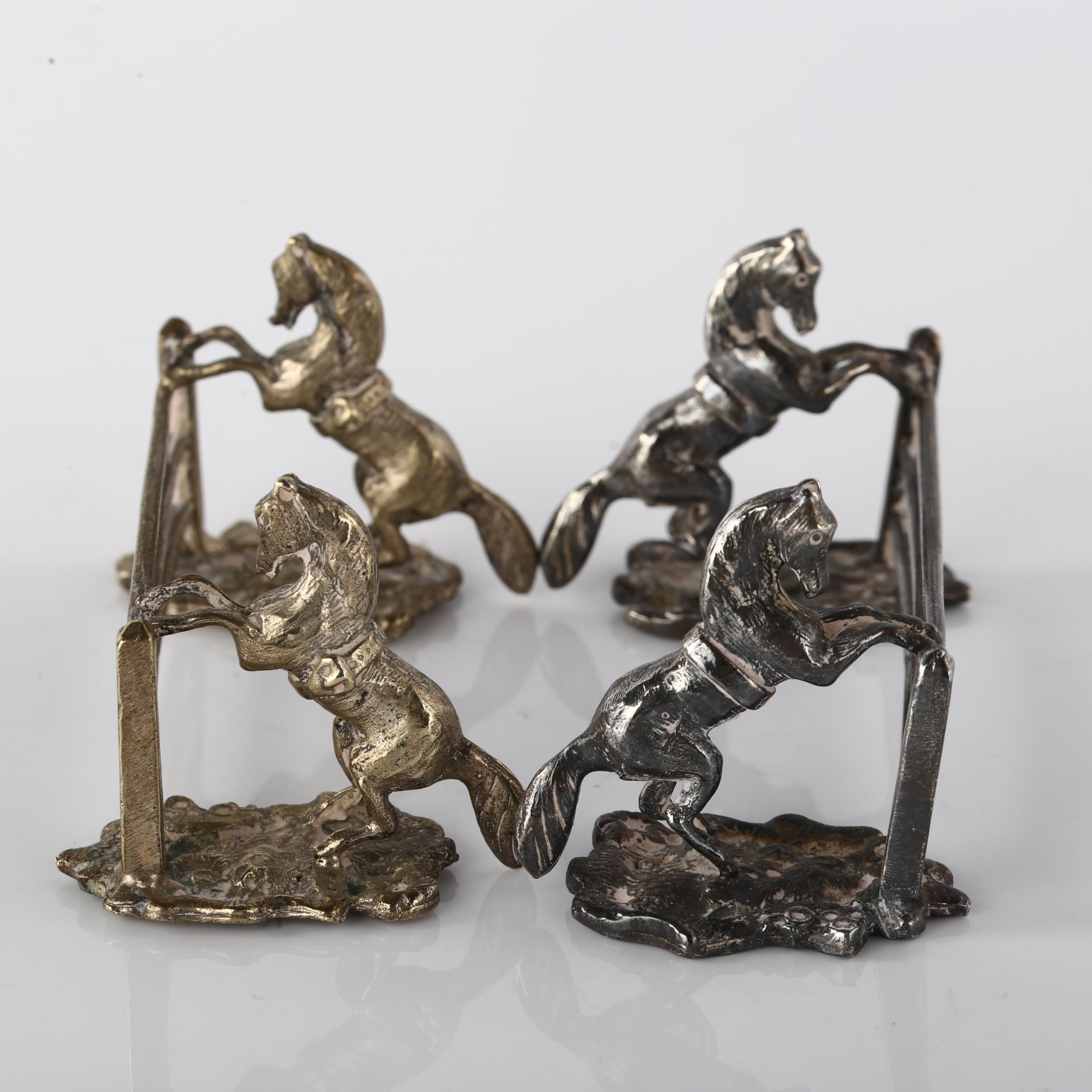 A pair of Antique silver plated novelty horse racing knife rests, modelled as horses jumping fences, - Image 2 of 3