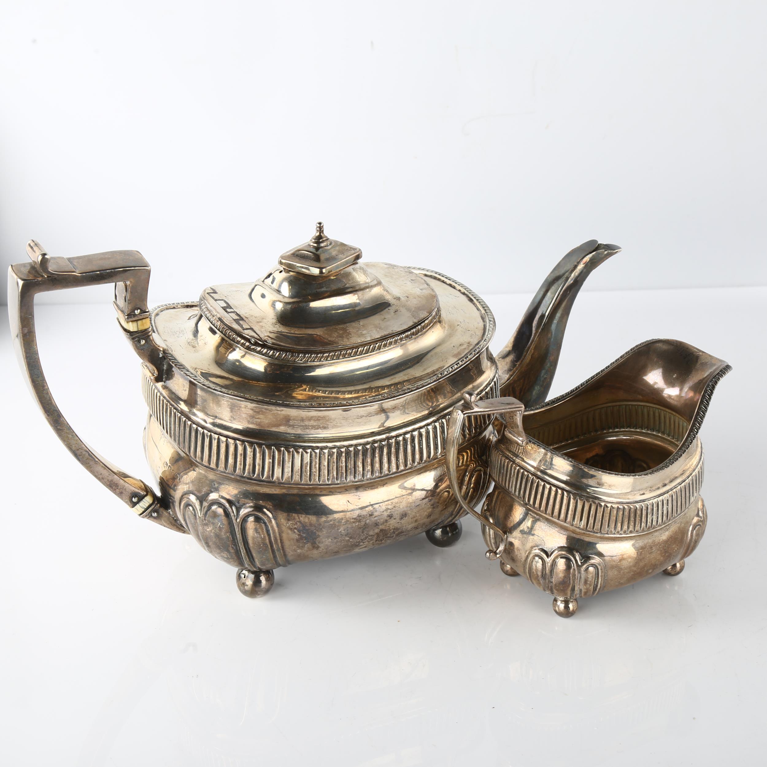 A George III silver teapot and cream jug set, oval bulbous form with half-fluted decoration, - Image 2 of 3