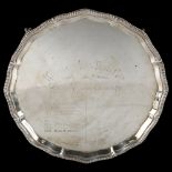 A George V silver presentation salver, circular form with scalloped and gadrooned rim, on claw and