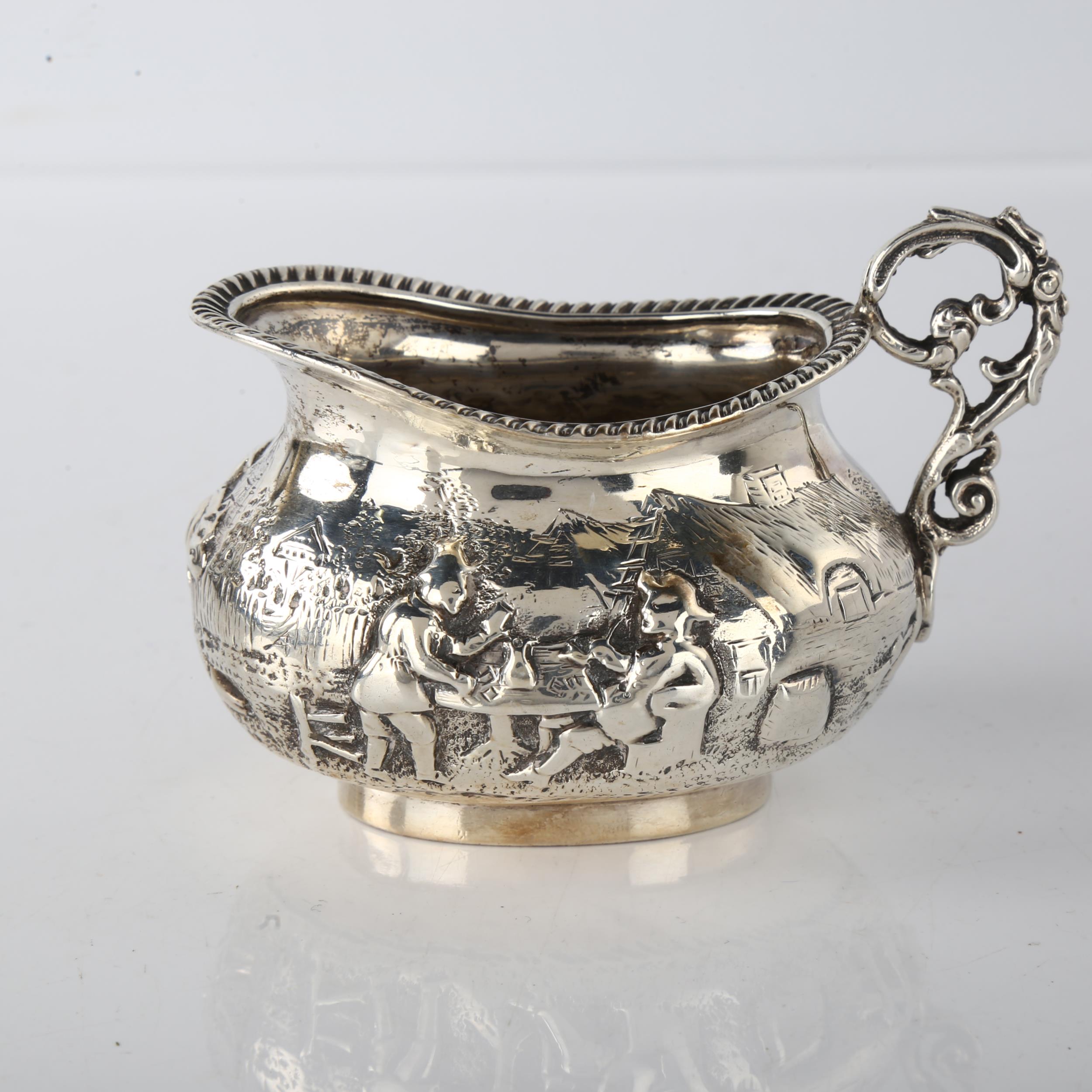 A Victorian silver cream jug, oval bulbous form with relief embossed village decoration and - Image 2 of 3