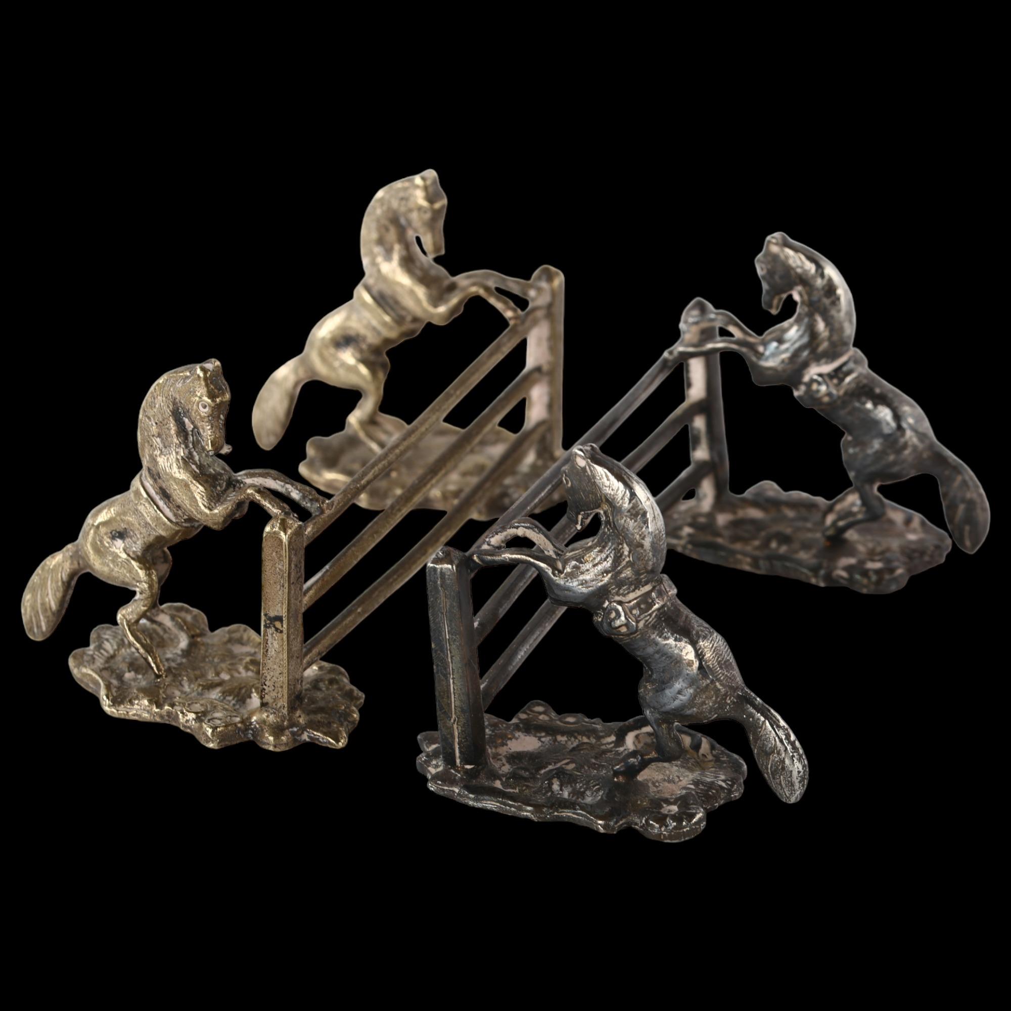 A pair of Antique silver plated novelty horse racing knife rests, modelled as horses jumping fences,