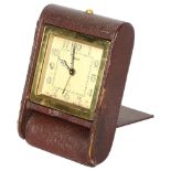 A Jaeger travelling alarm clock with 8-day movement, in snakeskin folding case, overall dial width