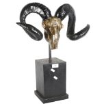 A decorative composite ram's head and antlers, on plinth stand, overall height 56cm