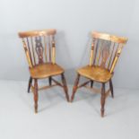 A pair of antique elm-seated dining chairs.