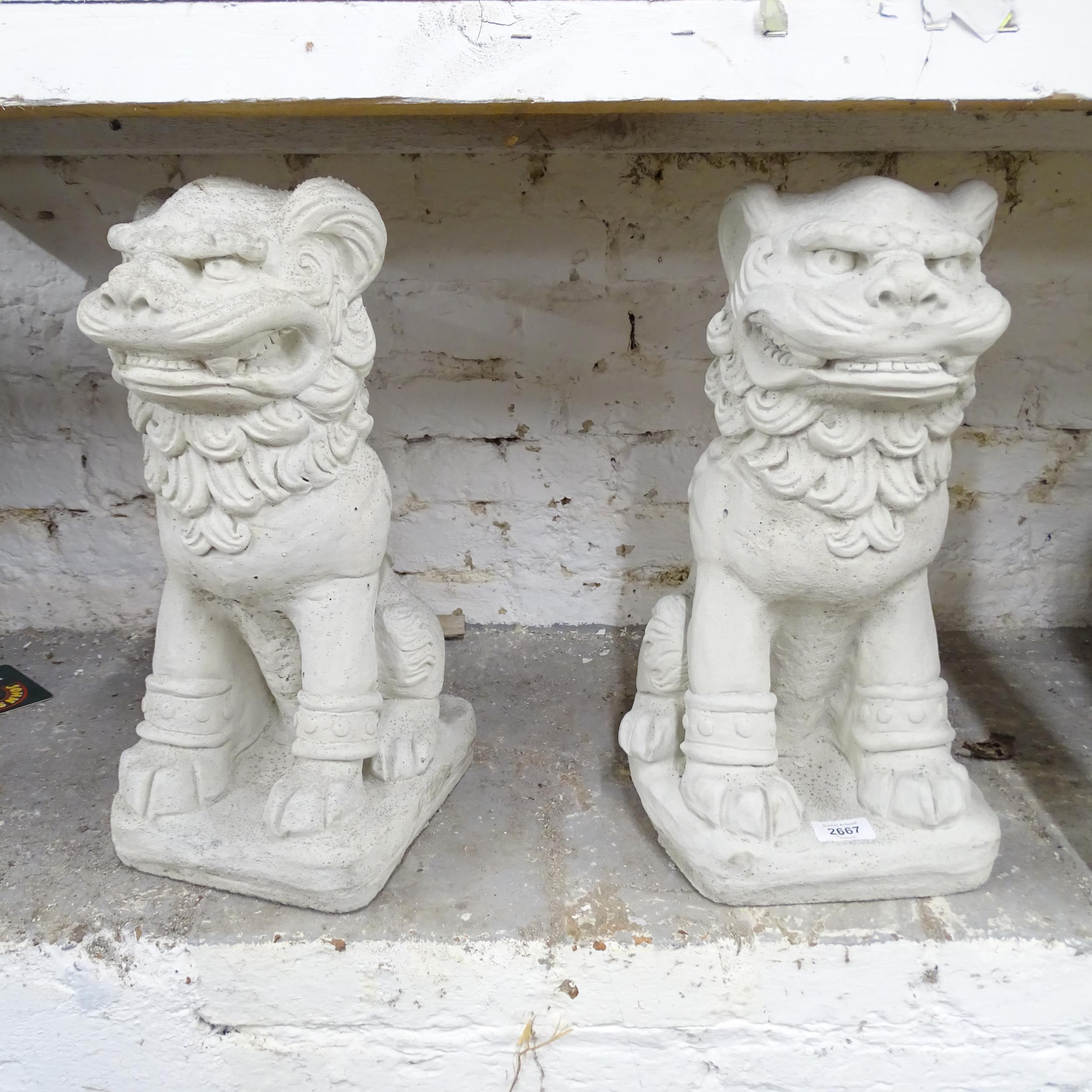 A pair of modern composite garden statues in the form of Dogs of Foo. Height 47cm.