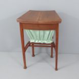 An Edwardian Arts & Crafts work table in the manner of Liberty, the top opening to reveal a fitted