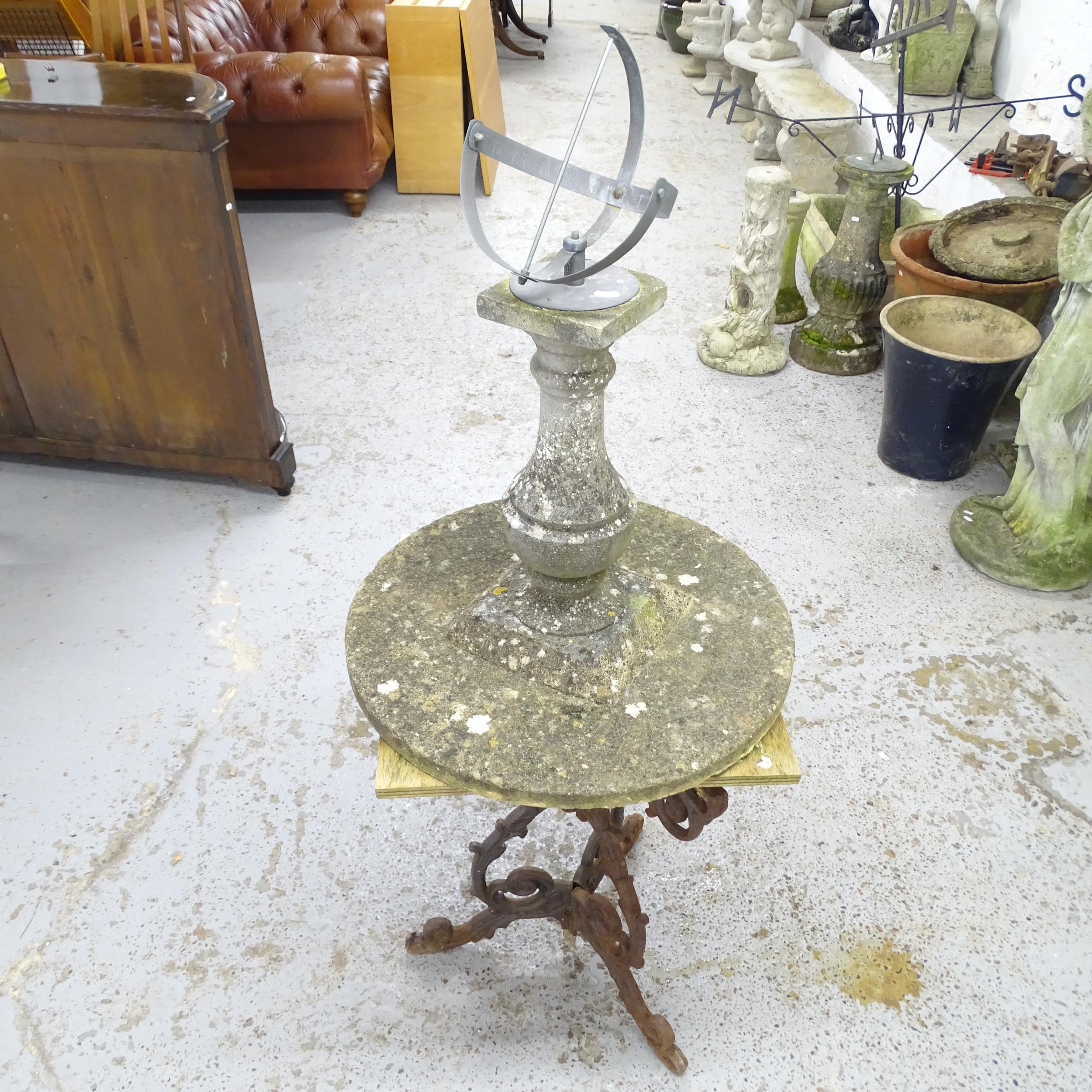 A weathered concrete sundial garden ornament, height 76cm, and an oak topped garden table cast