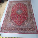 A red ground Tabriz carpet. 315x218cm