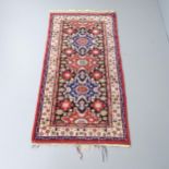 A red and cream-ground Caucasian rug. 192x94cm.