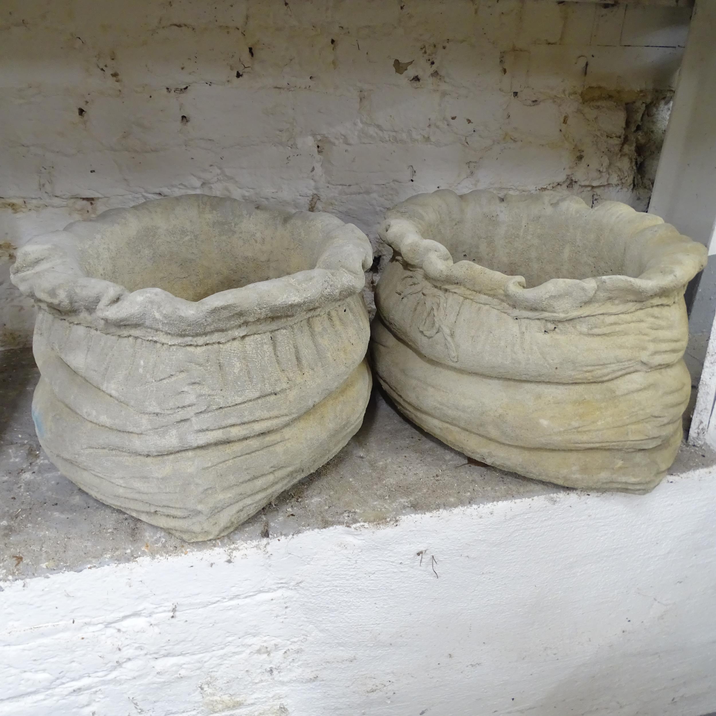 A pair of concrete sack design planters. 45x25cm.