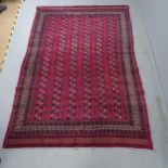 A red-ground Bokhara rug. 275x185cm.