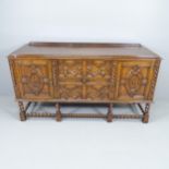 An early 20th century oak Jacobean style barley-twist sideboard with applied carved decoration.