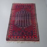 A red-ground Afghan rug. 183x115cm