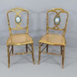A Pair of antique salon chairs, with gilded finish, featuring cane seats and hand painted ceramic