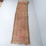 A red and cream-ground Turkish runner. 430x80cm Damage to all edges, areas of fading and pile