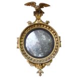 19th century convex wall mirror, elaborate carved giltwood frame surmounted by a giltwood eagle