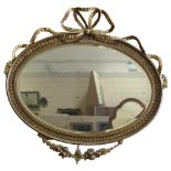 An oval gilt-gesso framed wall mirror, with ribbon pediment, circa 1920, width excluding ribbons