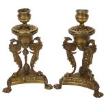 A pair of 19th century Empire style brass candlesticks, with phoenix supports and lion paw feet,