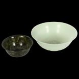 A jade bowl and a spinach jade bowl, on foot, 12.5cm across