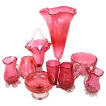 A group of cranberry glass jugs and vases, tallest 29cm