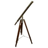 A reproduction brass telescope, on adjustable tripod stand