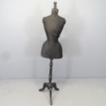 A vintage wasp-waisted shop display mannequin on stand. Height 153cm.