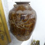 A large brown glazed jar, with Chinese style decoration. 45x67cm.