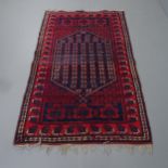 A red-ground Afghan rug. 183x115cm