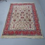 A red and cream ground Persian rug. 220x144cm.