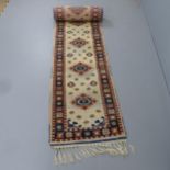 A cream-ground Persian design runner. 528x76cm discoloured patches. would benefit from a good clean.