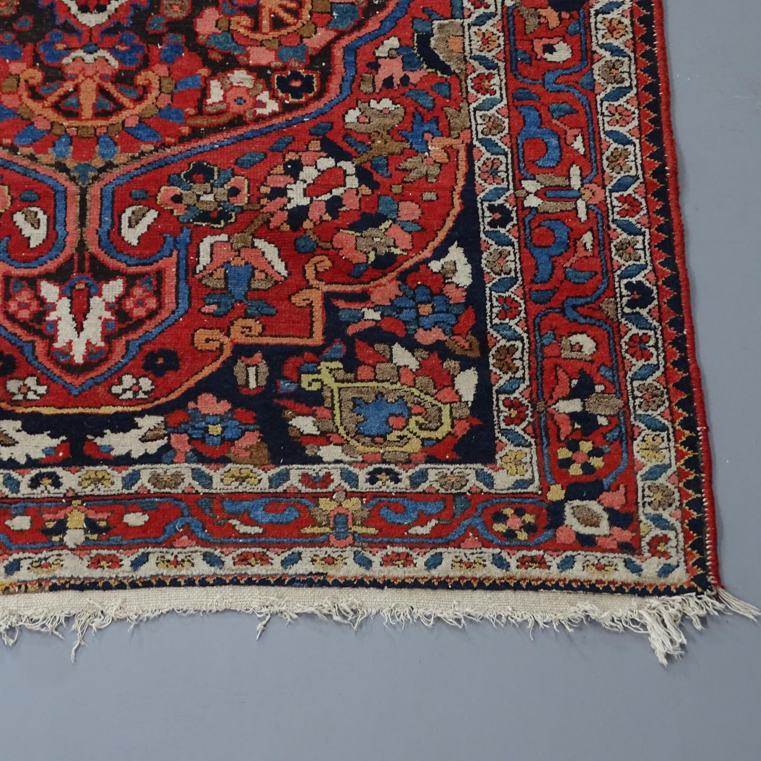 A red-ground Sarouk rug. 200x136cm Some damage to fringe, otherwise good condition. - Image 2 of 2