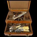 A 1920s oak drawer-fitted canteen with a quantity of mixed ivorine-handled and horn-handled