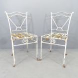 A pair of white painted wrought metal garden chairs.