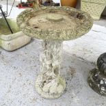 A weathered concrete two-section bird bath on tree trunk design base. 48x70cm.