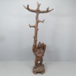 A large and impressive Black Forest hall stand in the form of a bear holding a branch, with hand