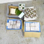 Three boxes of various tiles, and a stack of mosaic tiles.
