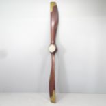 A large vintage aircraft propeller in mahogany with brass mounts, with inset clock. Length 250cm.